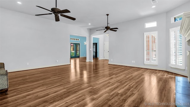 unfurnished living room with dark hardwood / wood-style floors and ceiling fan