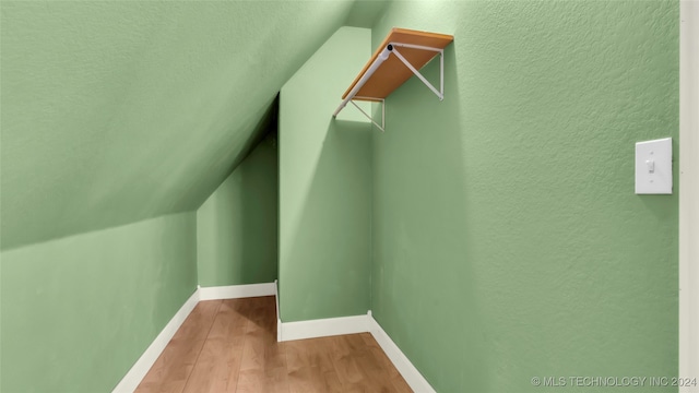 walk in closet featuring light wood-type flooring and lofted ceiling