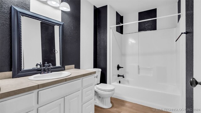 full bathroom featuring shower / bathtub combination, vanity, toilet, and hardwood / wood-style flooring