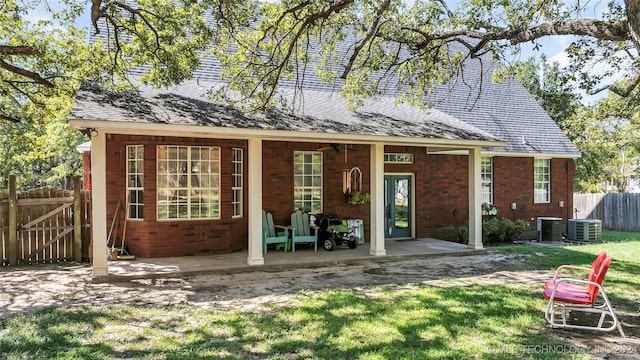 back of property featuring cooling unit, a yard, and a patio