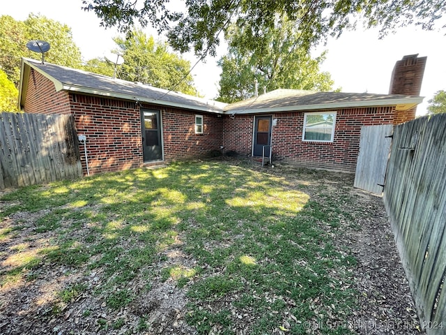 back of house featuring a lawn