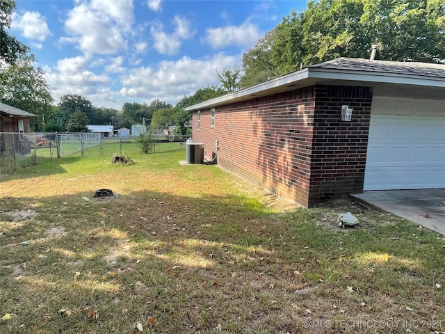 view of home's exterior featuring a yard, a garage, and central air condition unit