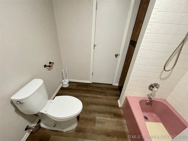 bathroom with wood-type flooring, toilet, and washtub / shower combination