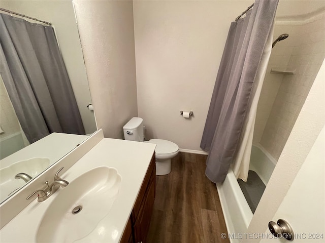 full bathroom featuring shower / bath combination with curtain, wood-type flooring, vanity, and toilet