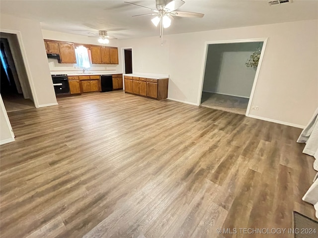 unfurnished living room featuring wood-type flooring, sink, and ceiling fan