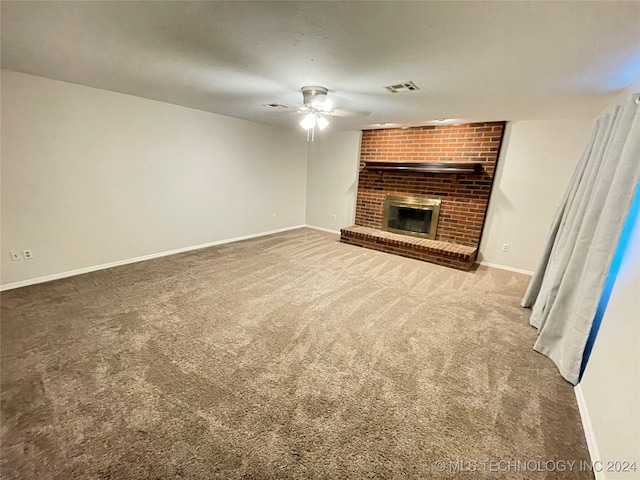 unfurnished living room with ceiling fan, carpet floors, and a fireplace