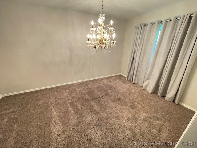 carpeted empty room with a notable chandelier