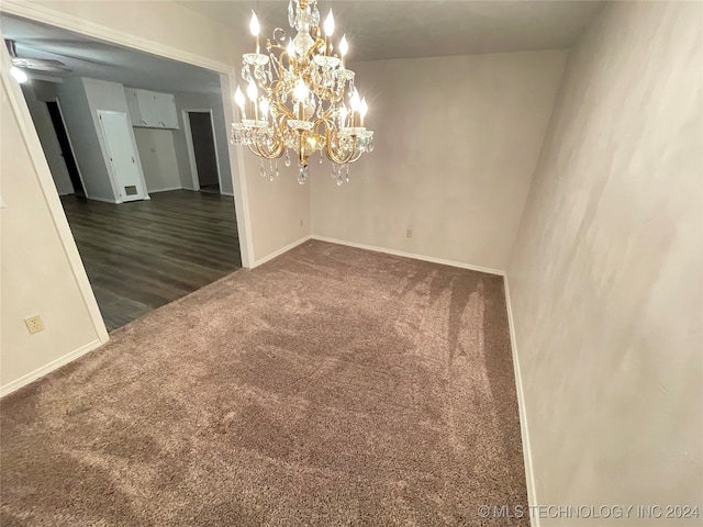 unfurnished room featuring ceiling fan with notable chandelier and dark hardwood / wood-style floors