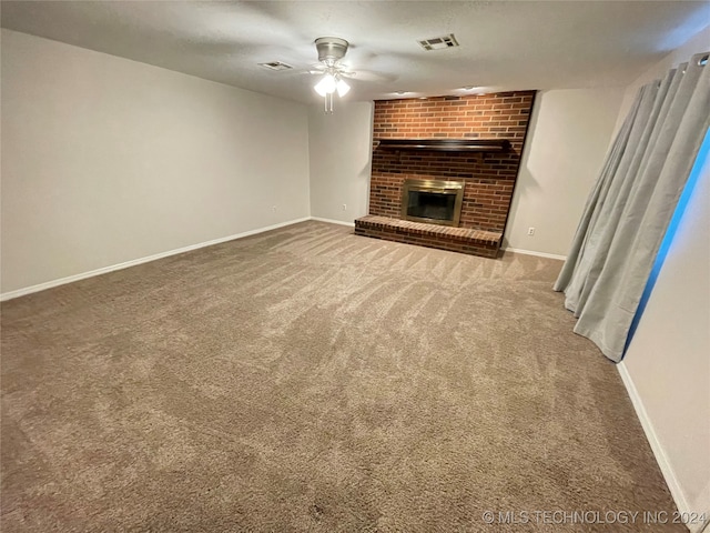 unfurnished living room with a brick fireplace, ceiling fan, and carpet flooring