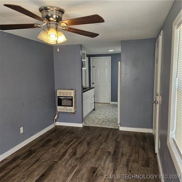 unfurnished living room with heating unit, ceiling fan, and dark hardwood / wood-style floors