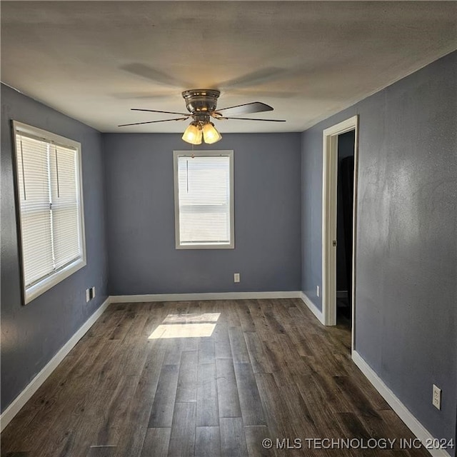 unfurnished room featuring ceiling fan and dark wood-type flooring