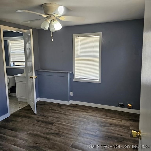 unfurnished room with ceiling fan and dark wood-type flooring