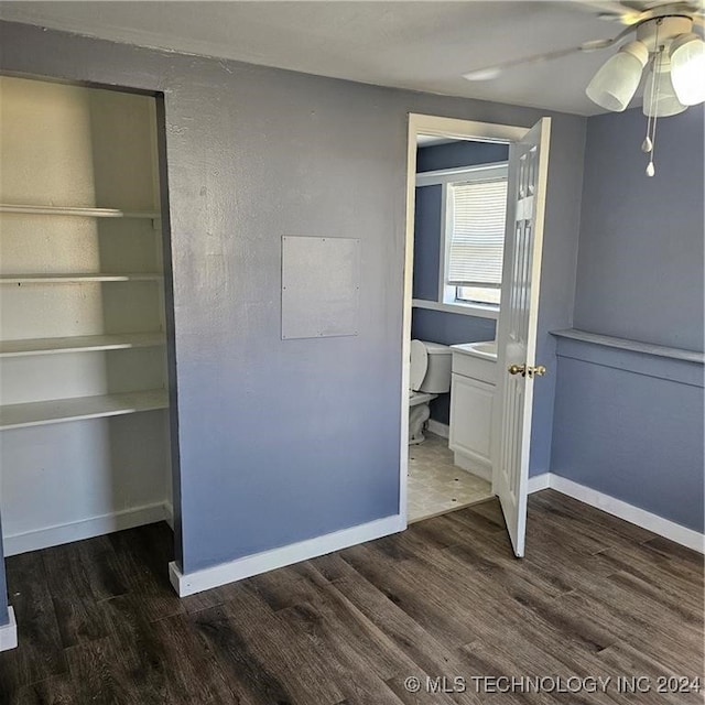 unfurnished bedroom featuring ceiling fan and dark hardwood / wood-style flooring