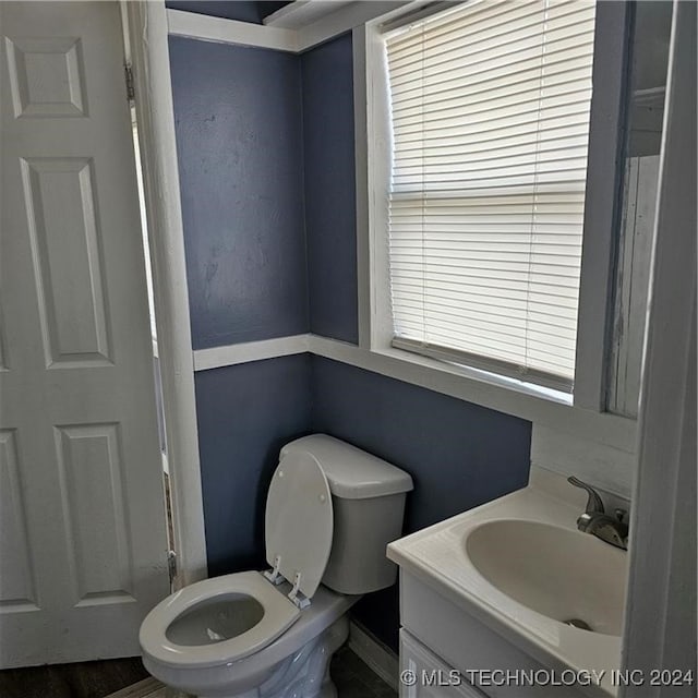 bathroom featuring a healthy amount of sunlight, vanity, and toilet