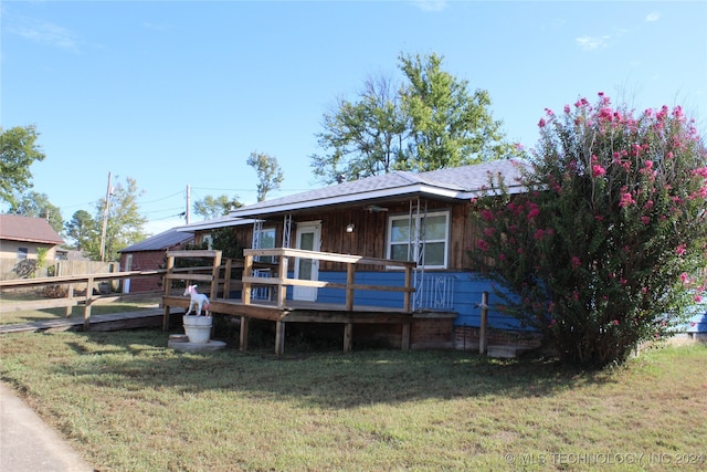 back of house featuring a deck and a yard