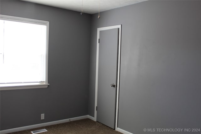 empty room featuring dark carpet