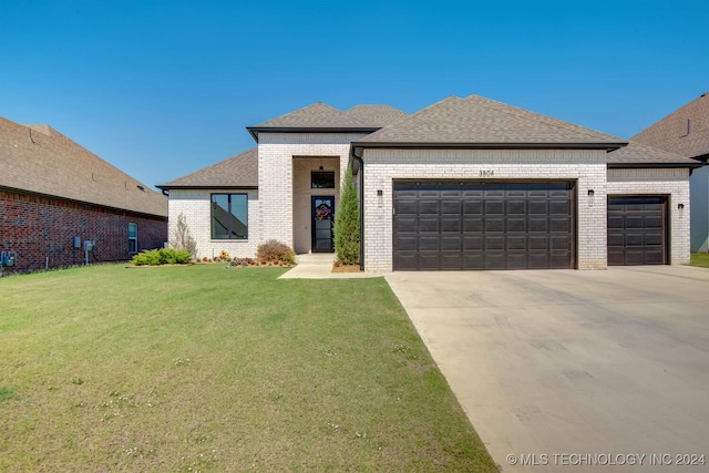 view of front of property featuring a garage and a front lawn