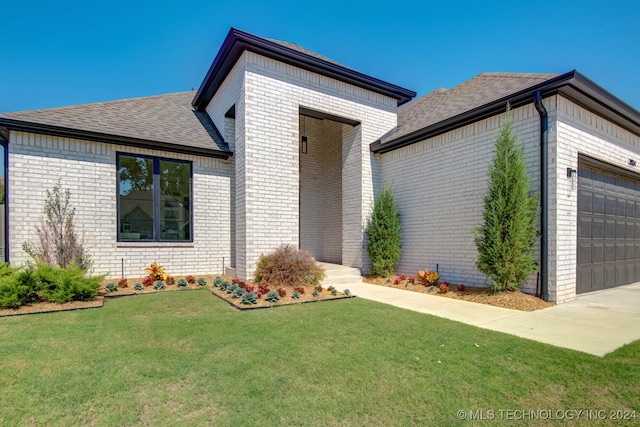 view of front of house with a garage and a front lawn