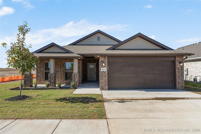 view of front of property featuring a front yard and a garage