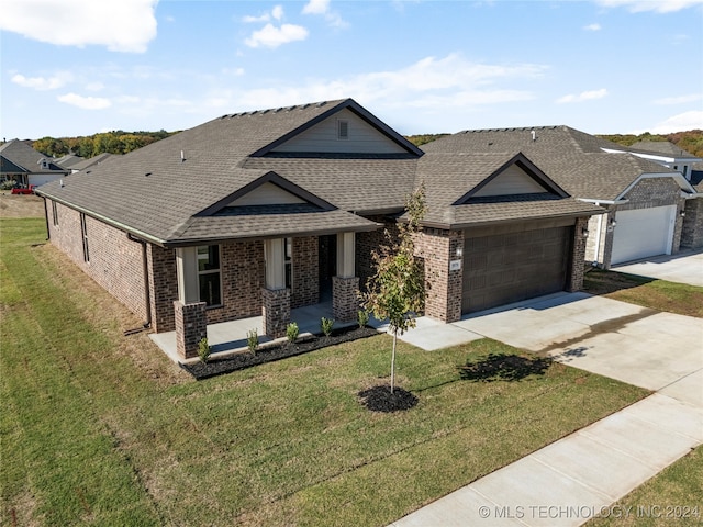 view of front of home with a front yard and a garage