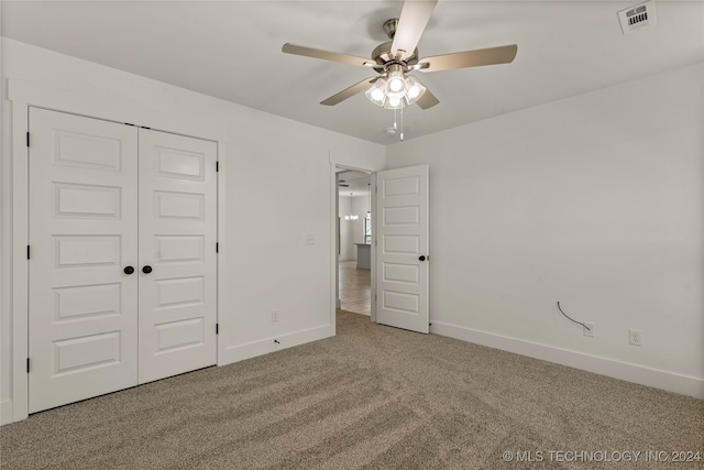 unfurnished bedroom featuring a closet, carpet floors, and ceiling fan