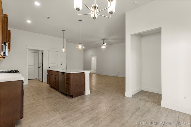 kitchen with hanging light fixtures, an island with sink, stainless steel dishwasher, light hardwood / wood-style floors, and sink