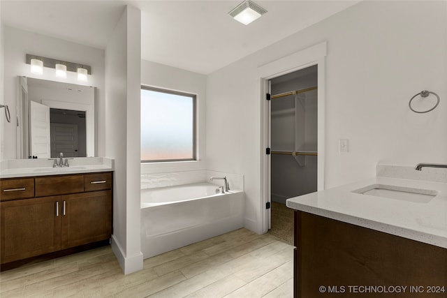 bathroom with vanity, wood-type flooring, and a bathing tub