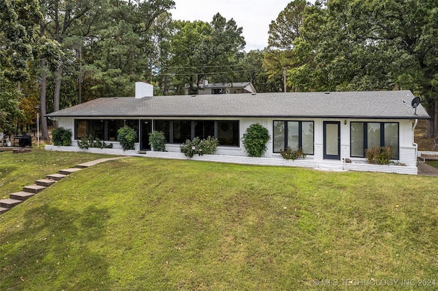 rear view of house with a yard