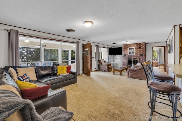 living room featuring a textured ceiling, a fireplace, and carpet flooring