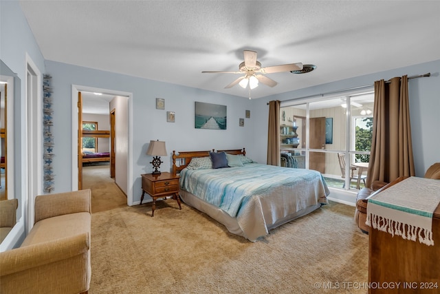 bedroom featuring light carpet, ceiling fan, and a textured ceiling