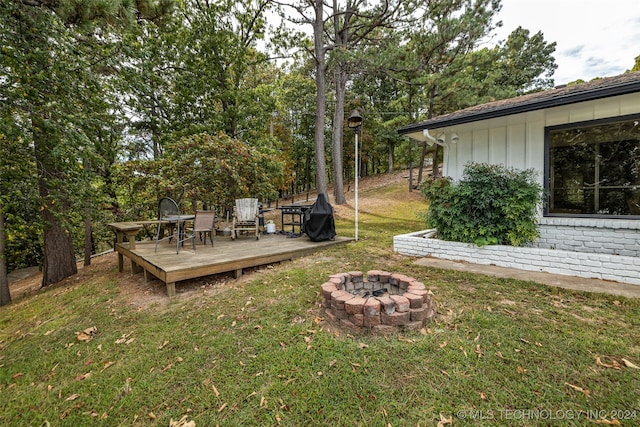 view of yard featuring a fire pit and a wooden deck