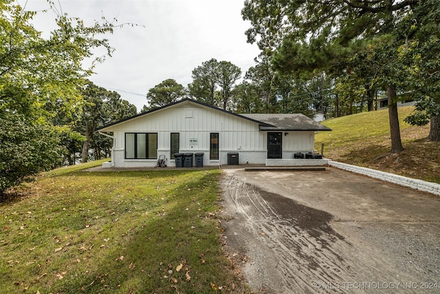 view of front of home featuring a front yard and central AC