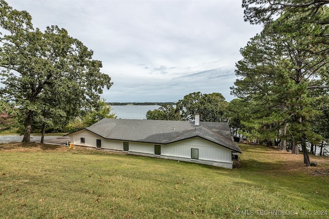 view of side of home featuring a lawn and a water view