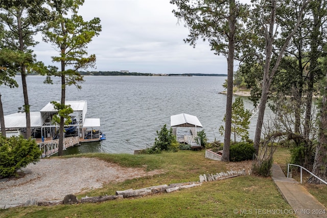 dock area with a lawn and a water view