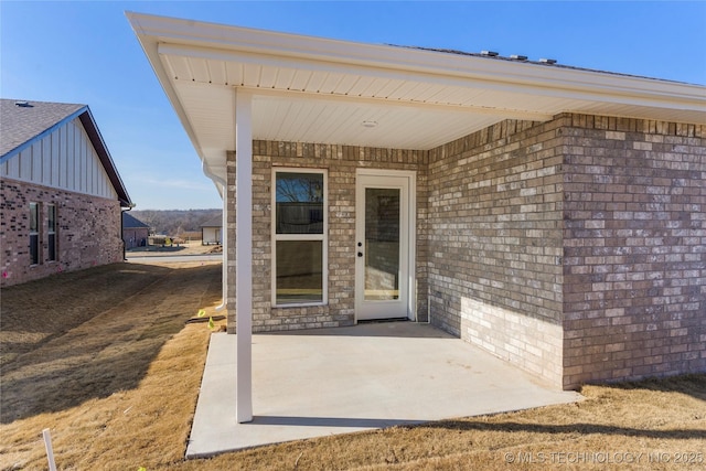 view of exterior entry featuring a patio