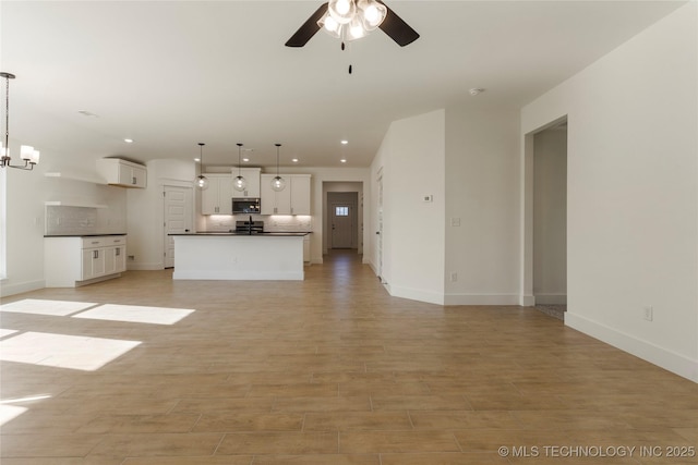 unfurnished living room featuring ceiling fan