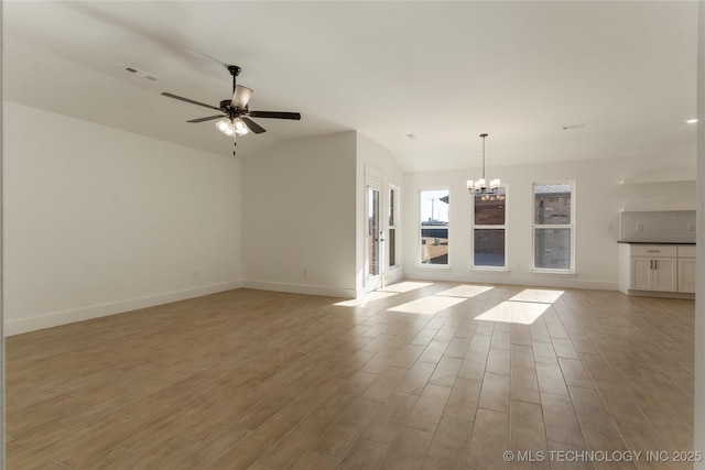 unfurnished living room featuring lofted ceiling and ceiling fan with notable chandelier