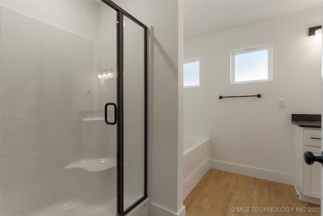 bathroom featuring separate shower and tub, hardwood / wood-style flooring, and vanity