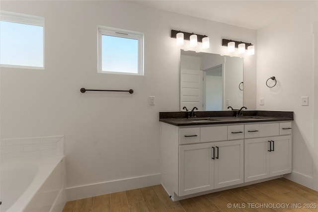 bathroom with a washtub and vanity