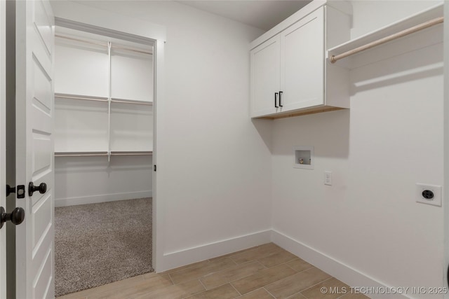 washroom with cabinets, electric dryer hookup, and hookup for a washing machine