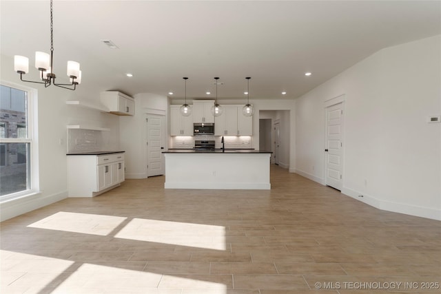 kitchen featuring stainless steel appliances, pendant lighting, white cabinets, and sink