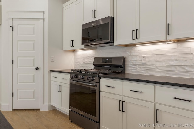 kitchen featuring tasteful backsplash, appliances with stainless steel finishes, white cabinetry, and light hardwood / wood-style floors