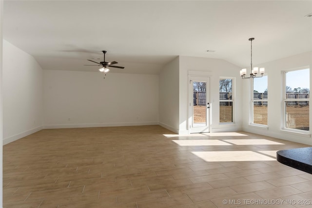 interior space featuring ceiling fan with notable chandelier and vaulted ceiling