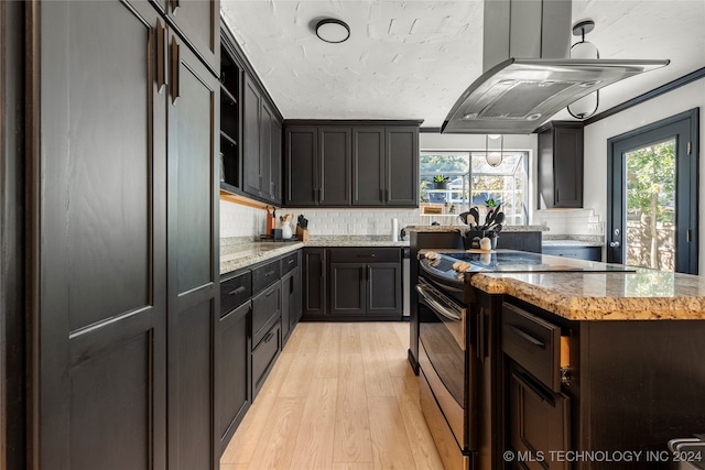 kitchen with light hardwood / wood-style floors, stainless steel electric stove, tasteful backsplash, and crown molding