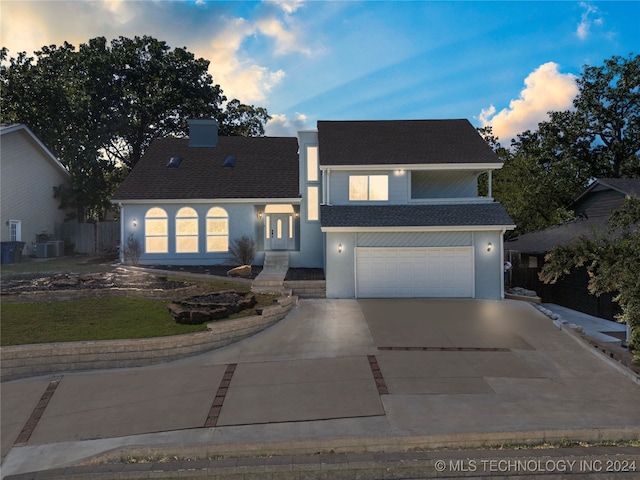 view of front of home featuring a garage and central AC