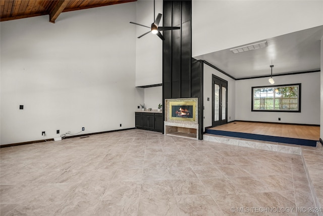 unfurnished living room featuring wood ceiling, ceiling fan, beamed ceiling, and high vaulted ceiling