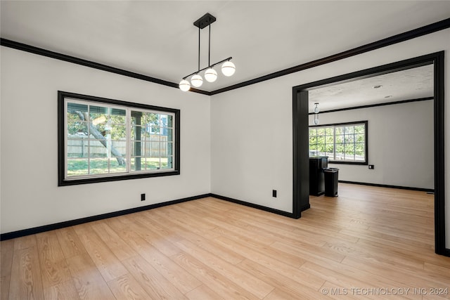 empty room featuring light wood-type flooring and ornamental molding