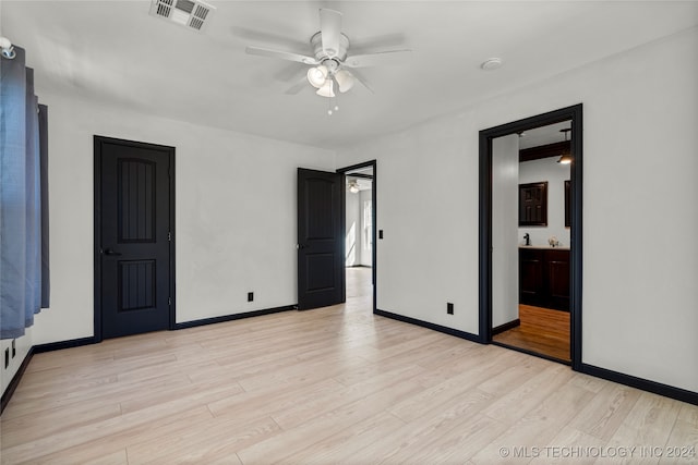 unfurnished bedroom featuring connected bathroom, light hardwood / wood-style floors, and ceiling fan