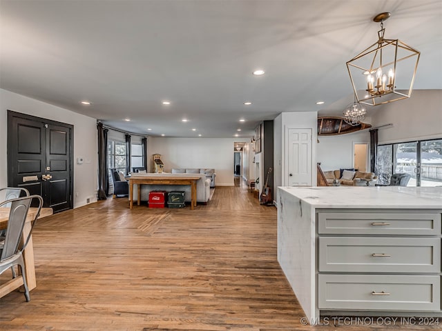 kitchen with light wood-type flooring, a healthy amount of sunlight, and light stone countertops