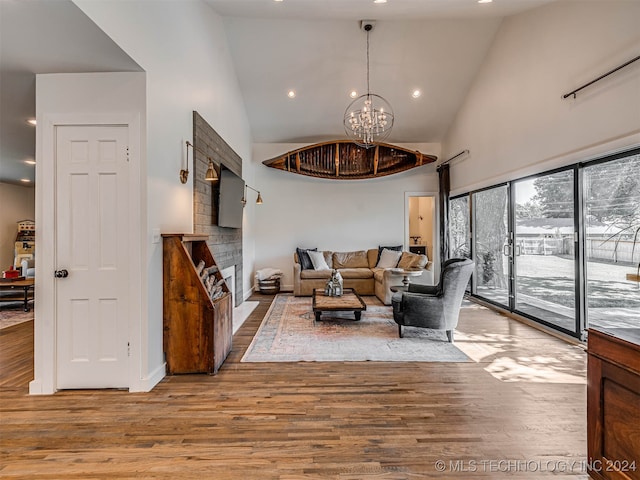 living room featuring an inviting chandelier, light hardwood / wood-style floors, and high vaulted ceiling